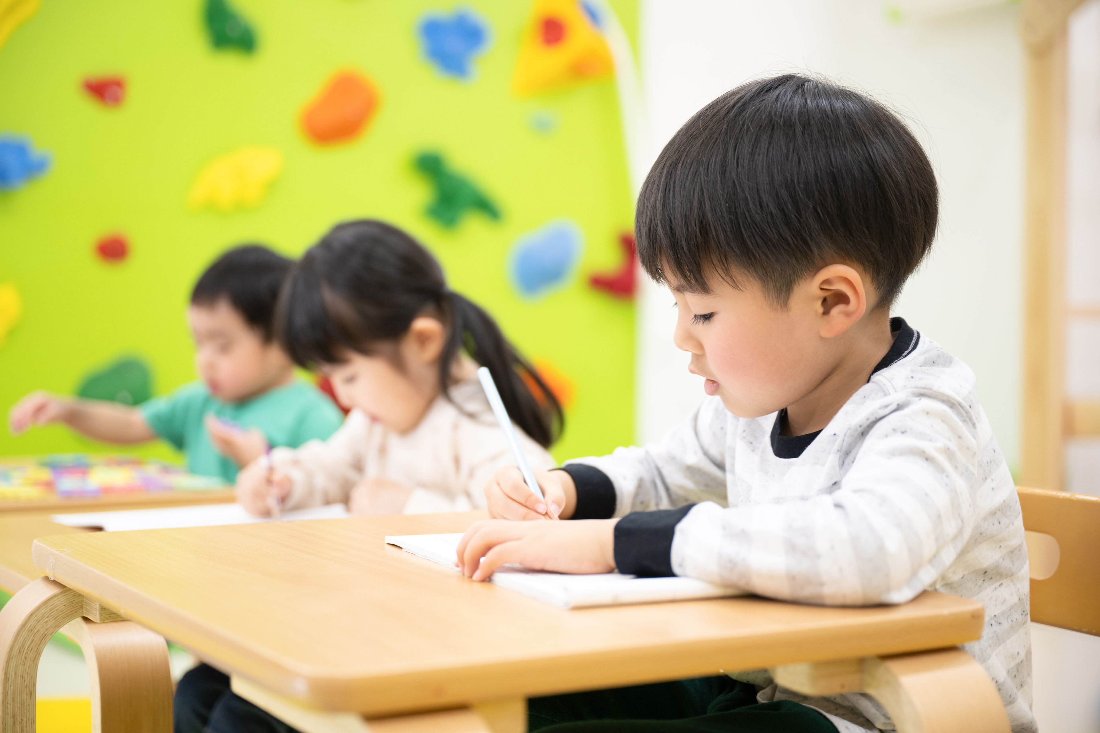 机に向かって宿題をする子どもたち